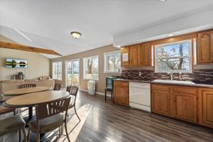 a kitchen with wooden cabinets and a table and chairs at Shady Gator House Sleep 20 Bachelor and Bachelorette Parties Welcome in Lake Ozark