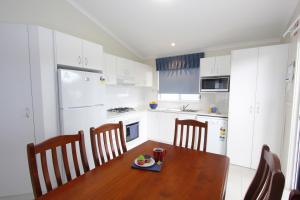a kitchen with a wooden table with a plate of food on it at Windang Tourist Park in Windang