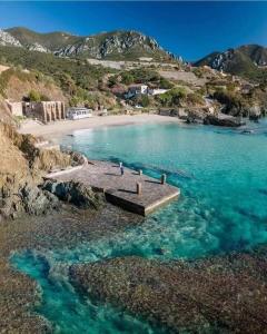 une plage avec un quai au milieu de l'eau dans l'établissement Casa Greta, à Iglesias