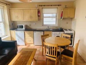 a kitchen with a wooden table and a table and chairs at Sea view Flat Cobh in Cobh