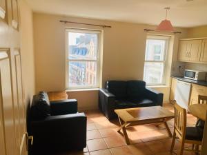 a living room with two couches and a table at Sea view Flat Cobh in Cobh