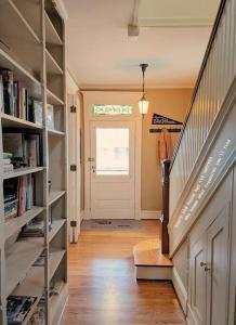 a hallway with a staircase and a door with books at Stylish Victorian in Historic District in Cambridge