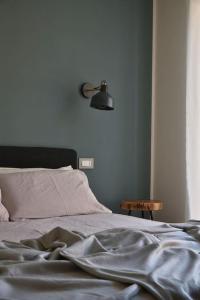 ein Schlafzimmer mit einem Bett mit einer Lampe an der Wand in der Unterkunft Sky & Vineyards - Mora - in La Morra