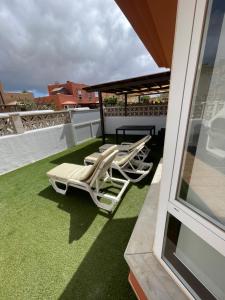 two lounge chairs and a table on a balcony at Aeren House in Corralejo