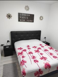 Un dormitorio con una cama con flores rojas. en Maison plein pied 1, en Hérin