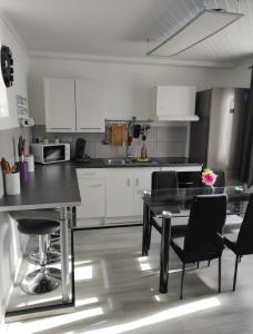 a kitchen with a table and chairs in a room at Charmante Maison à Hérin-plain-pied, clim,Wi-Fi in Hérin +10 photos