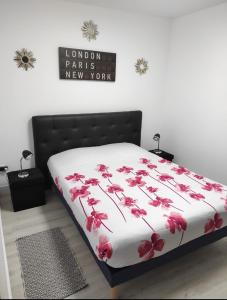 Una cama con flores rojas en una habitación en Maison plein pied 1, en Hérin