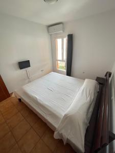 un letto bianco in una stanza con finestra di Aeren House a Corralejo