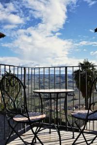2 Stühle und ein Tisch auf einem Balkon mit Aussicht in der Unterkunft Sky & Vineyards - Mora - in La Morra