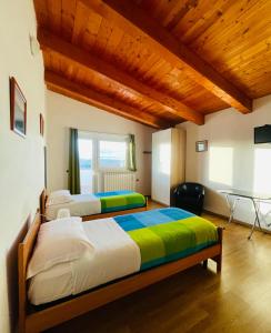 2 bedden in een kamer met houten plafonds bij IL GLICINE CAMPAGNOLO in Atessa