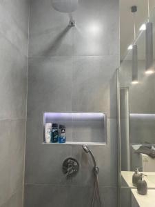 a bathroom with a shower with a shower head at London Apartman Szeged in Szeged