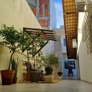 Un callejón con plantas en macetas al costado de un edificio. en Pousada Vila Regina, en Penha