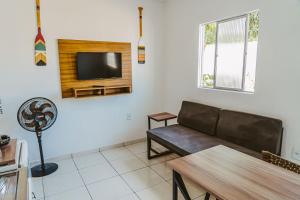 a living room with a couch and a tv on a wall at Otimo chale c WiFi e boa localizacao - Parnaiba PI in Parnaíba