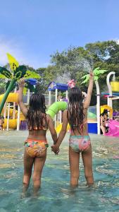 two girls in the water at a water park at Rafain Palace Hotel & Convention Center in Foz do Iguaçu