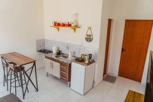 cocina con encimera, fregadero y mesa en Chale c otima localizacao e Wi-Fi em Parnaiba PI, en Parnaíba