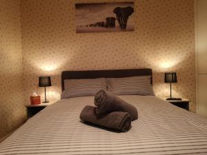 a bedroom with a bed with a towel on it at MossBank House Luton Airport in Luton +10 photos