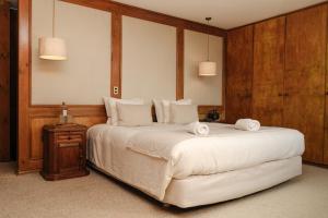 um quarto com uma cama grande e toalhas em Lodge Parque Tepuhueico em Castro