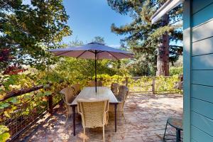 un tavolo con ombrellone su un patio di Boho Wine Country Farmhouse Retreat a Sebastopol