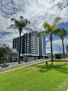 a large building with palm trees in a park at Emy's City Center Flat at 77 on Independence in Windhoek