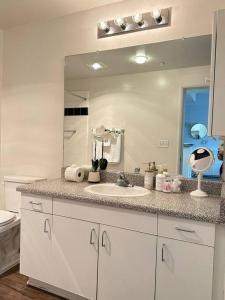 ein Badezimmer mit Waschbecken und großem Spiegel in der Unterkunft Luxe Marina Del Rey Apartment,Parking, Gym, Pool, jacuzzi,BBQ in Los Angeles