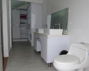 a white bathroom with a toilet and a sink at HOTEL PURA VIDA in Santa Rosa de Cabal