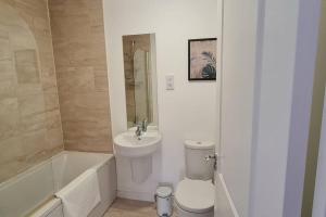a bathroom with a toilet and a sink and a tub at Convenient & cosy 3 bed house in Newport