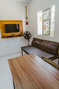 ein Wohnzimmer mit einem Tisch und einem Sofa in der Unterkunft Chale c otima localizacao e Wi-Fi em Parnaiba PI in Parnaíba