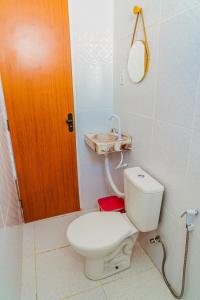 baño con aseo blanco y puerta de madera en Chale c otima localizacao e Wi-Fi em Parnaiba PI, en Parnaíba