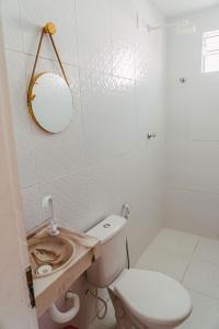 La salle de bains est pourvue de toilettes, d'un lavabo et d'un miroir. dans l'établissement Chale c otima localizacao e Wi-Fi em Parnaiba PI, à Parnaíba