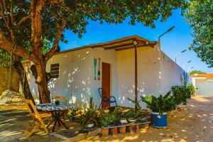 ein kleines weißes Haus mit einem Tisch und einem Baum in der Unterkunft Chale c otima localizacao e Wi-Fi em Parnaiba PI in Parnaíba