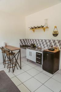 a kitchen with a counter and a table and a stove at Chale com excelente localizacao e WiFi em Parnaiba in Parnaíba