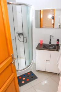 uma casa de banho com um chuveiro, um lavatório e um espelho. em Paris Hotel em Praia
