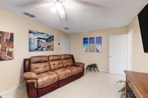 a living room with a brown leather couch at Evergreen Escape in Orlando