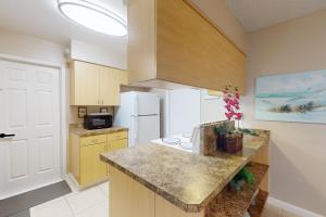 a kitchen with a counter and a white refrigerator at Evergreen Escape in Orlando