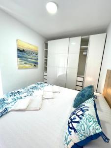 a bedroom with a large white bed with pillows at SeawaveSunGranCanaria in Telde