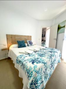 a bedroom with a large bed with a blue and white blanket at SeawaveSunGranCanaria in Telde