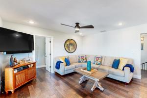 uma sala de estar com um sofá e uma televisão de ecrã plano em The Colorful Cabana em Key Largo