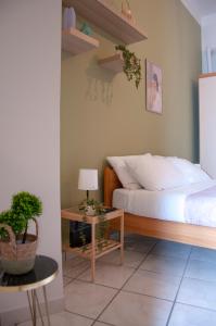 Le Muse Loft في كازيرتا: غرفة نوم بسرير وطاولة مع مصباح