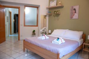 Le Muse Loft في كازيرتا: غرفة نوم بها سرير عليه منشفتان