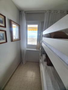 a bedroom with a bunk bed and a window at Beach front room NOT A HOTEL in Castelldefels