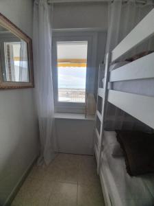 a bedroom with a bunk bed and a window at Beach front room NOT A HOTEL in Castelldefels