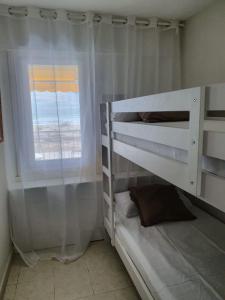 a bedroom with two bunk beds and a window at Beach front room NOT A HOTEL in Castelldefels