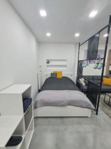 ein weißes Schlafzimmer mit einem Bett und einem Spiegel in der Unterkunft London Apartman Szeged in Szeged