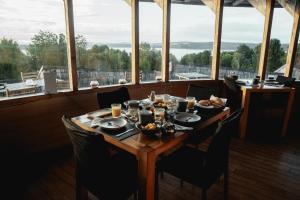 a table with food on it in a room with windows at Lodge Parque Tepuhueico in Castro