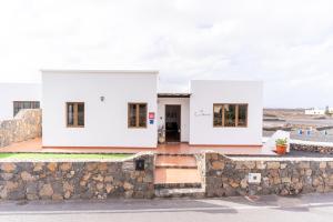 una casa blanca en la parte superior de una pared de piedra en CASA TERE Y MARCIAL en Tinajo