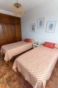1 dormitorio con 2 camas y lámpara de araña en CASA TERE Y MARCIAL en Tinajo