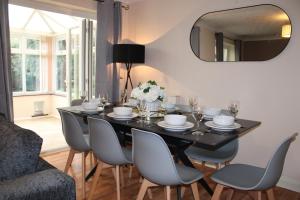 a dining room with a black table and chairs at 5 star, 5 Bedroom Home in Ely in Ely