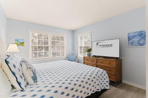 a bedroom with a bed and a tv on a dresser at OceanWood, Unit 101 in East End