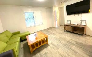 a living room with a green couch and a coffee table at Private Room near downtown Dallas42 in Dallas