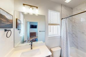 a white bathroom with a sink and a shower at Blue Skies Over Butler Creek in Belgrade